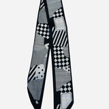 Black and white twilly scarf with geometric patchwork and checkerboard prints.