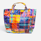 Glossy PVC tote bag with bright multicolor orange, purple, blue, yellow, teal, and pink plaid.