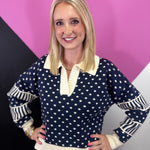 Navy and cream polka dot sweater with oversized collar, split neckline, and striped sleeves.