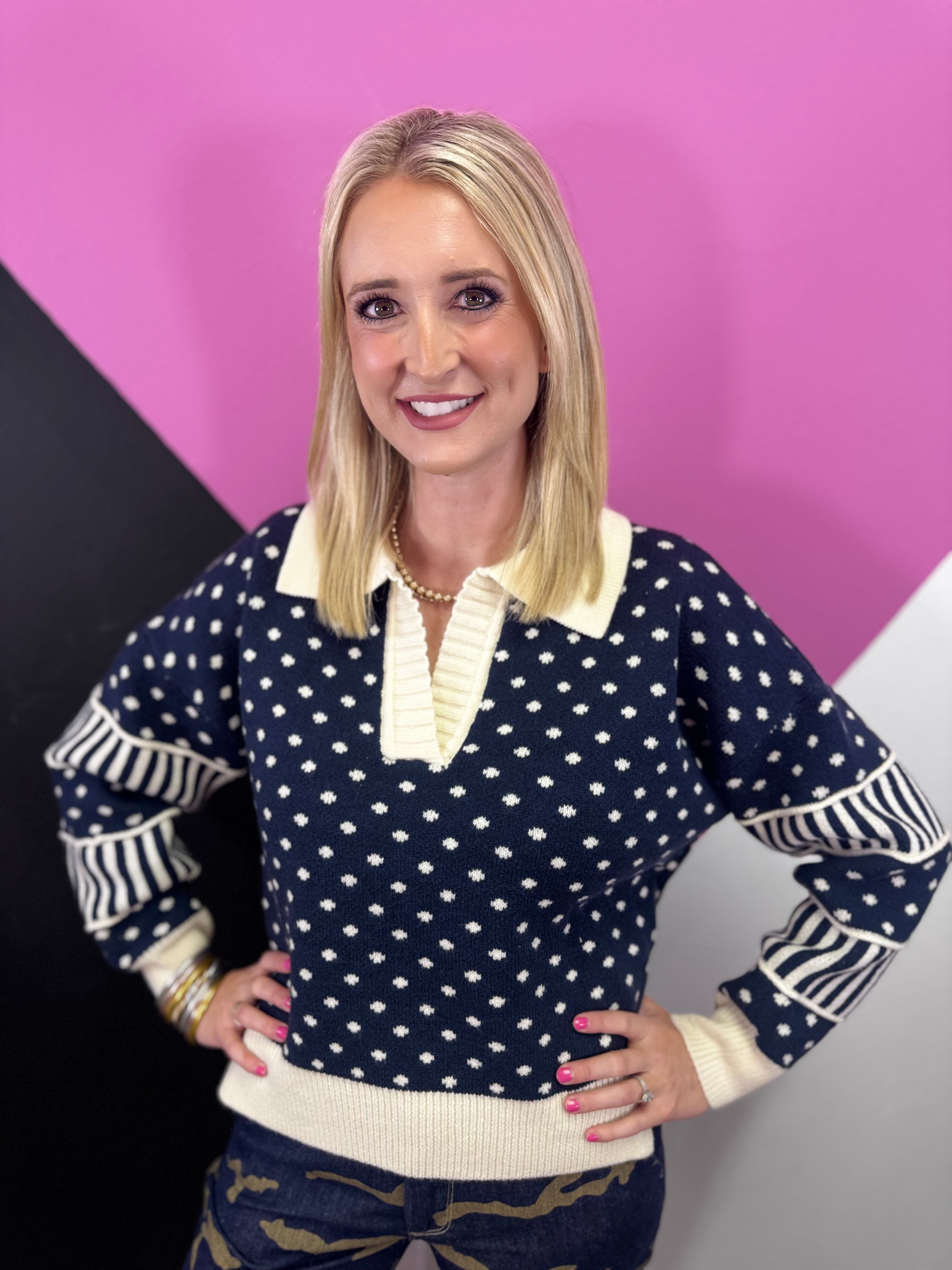 Navy and cream polka dot sweater with oversized collar, split neckline, and striped sleeves.