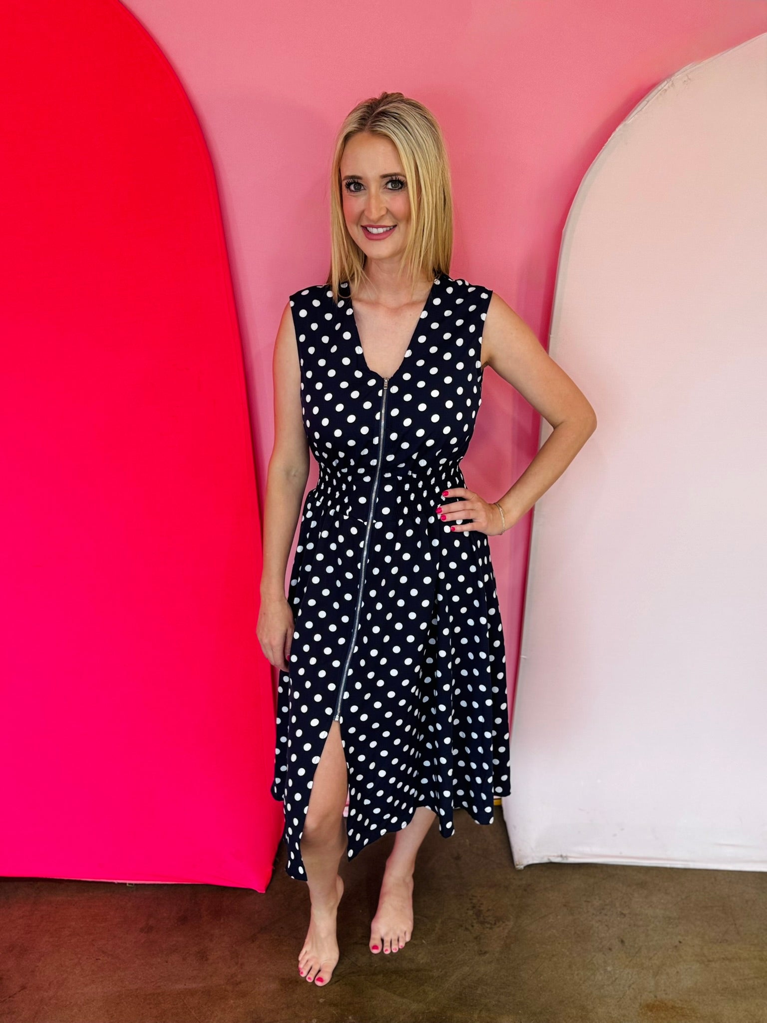 Navy polka dot midi dress with front zipper and elastic waist.