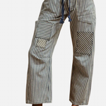 Navy striped twill barrel pants with rope tie, decorative pockets, and relaxed cotton fit.