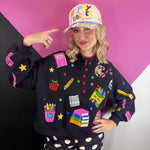 Black teacher pullover with colorful sequin school supplies, stars, and red button details.