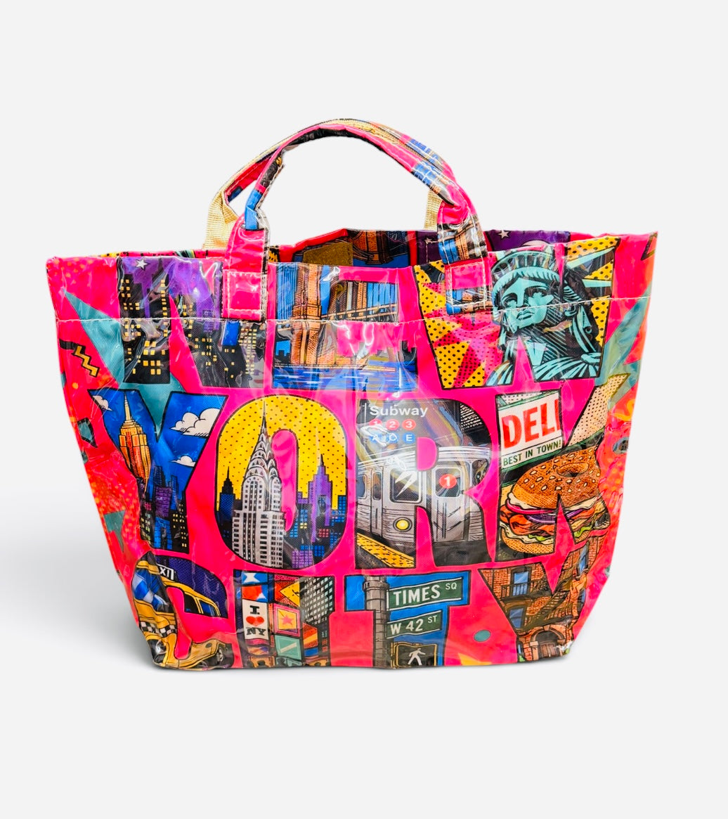 Hot pink NYC tote bag with colorful Statue of Liberty, skyline, subway, and Brooklyn Bridge collage.