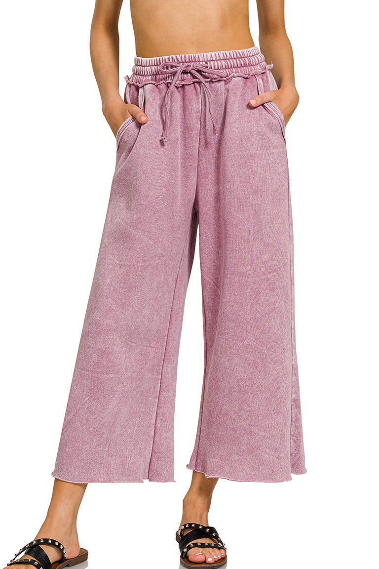 Light rose acid wash wide-leg fleece palazzo sweatpants with drawstring waist, raw hem, and pockets.