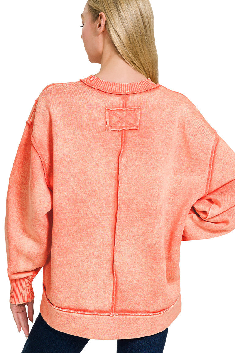 Coral acid wash fleece sweatshirt with exposed seams and side slits.