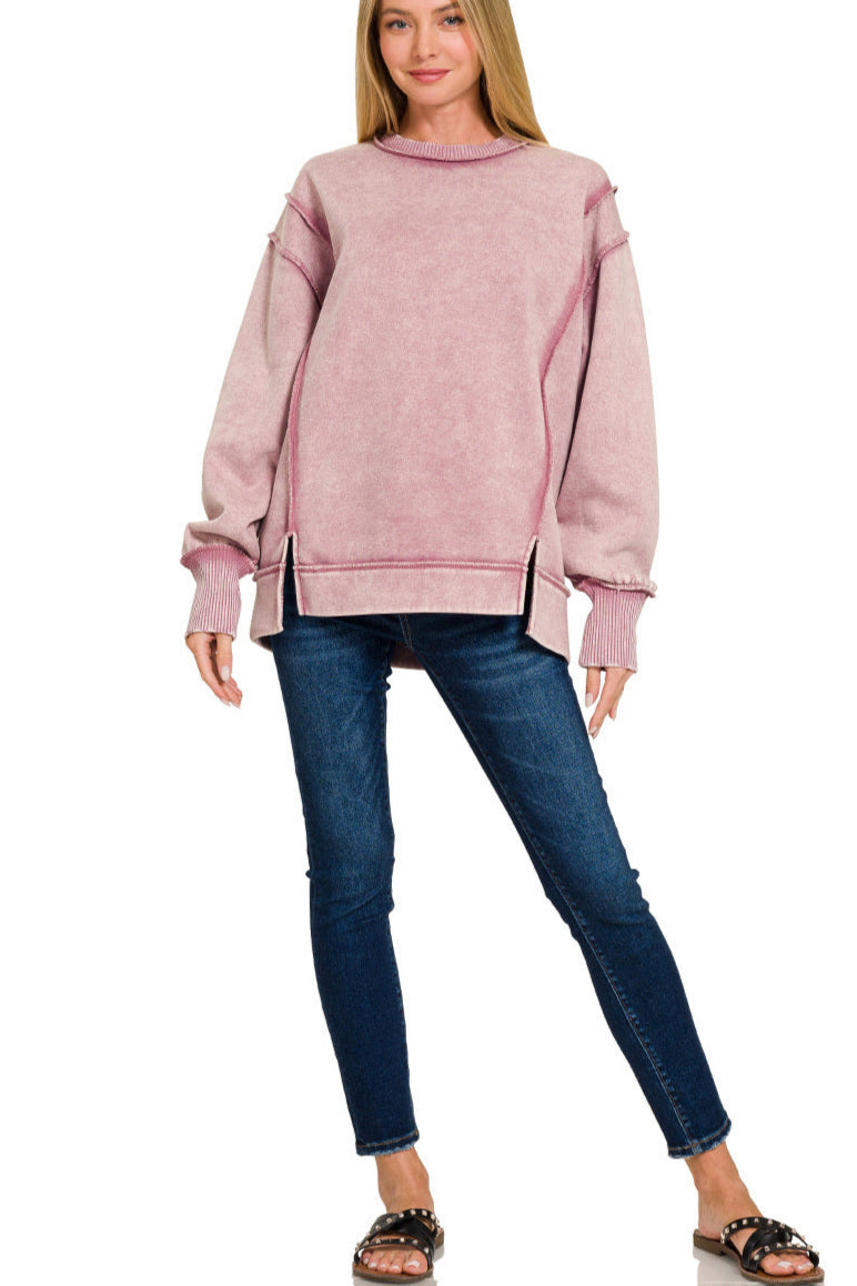 Light rose acid wash fleece sweatshirt with exposed seams and side slits.