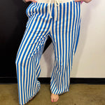 Ocean blue and white vertical striped wide leg pants with drawstring waist and pockets.