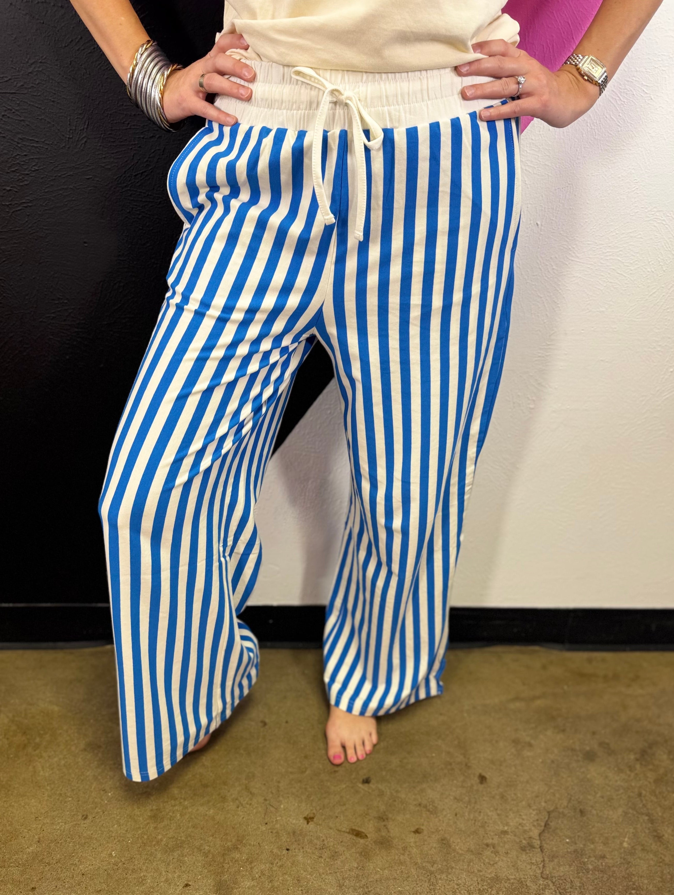 Ocean blue and white vertical striped wide leg pants with drawstring waist and pockets.