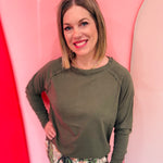 Olive cotton raglan top with thumbhole cuffs.