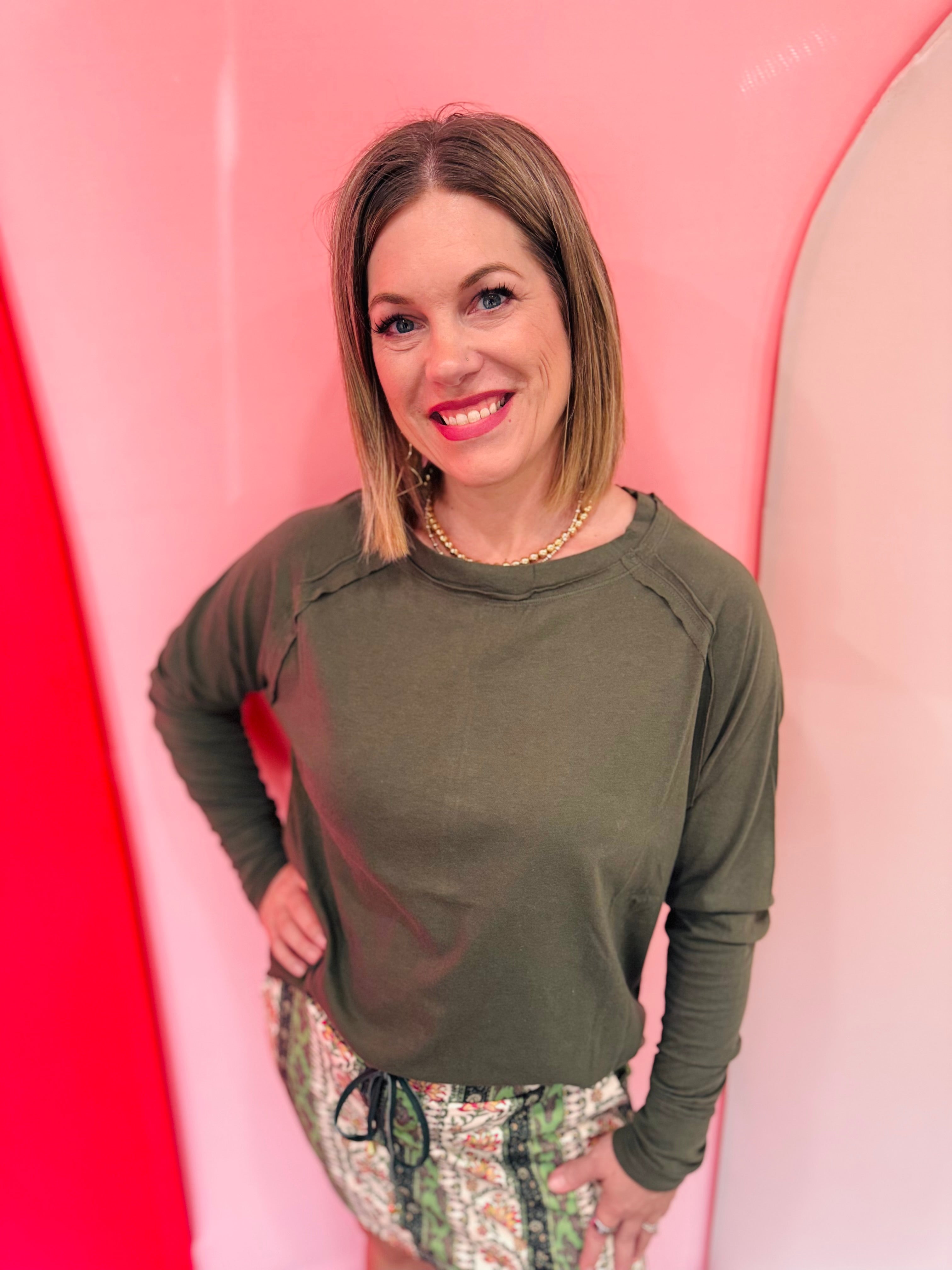 Olive cotton raglan top with thumbhole cuffs.
