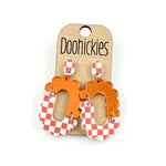 Orange checkered acrylic dangle earrings with hypoallergenic stainless steel settings.