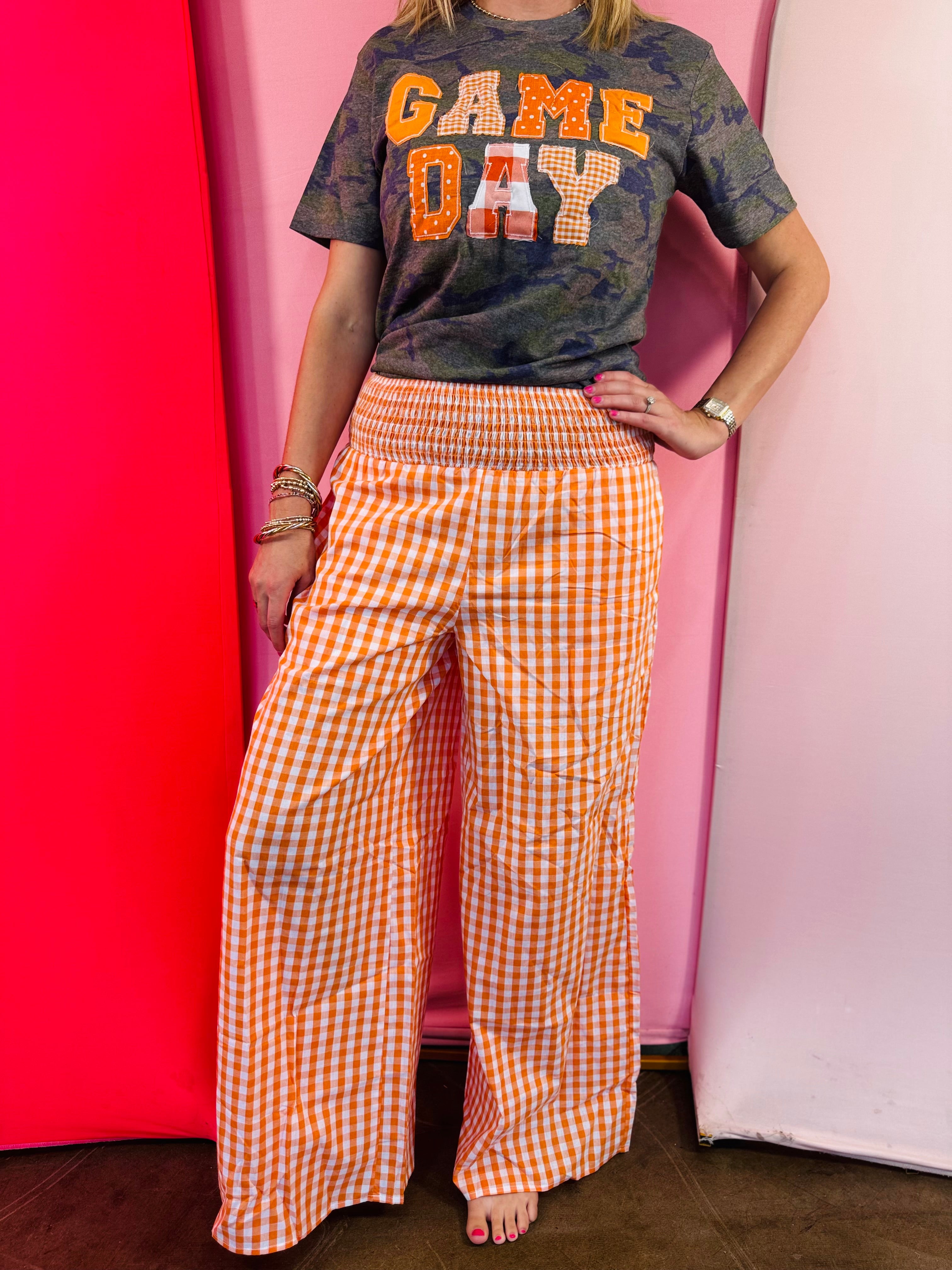 Orange and white gingham wide leg pants with a smocked waistband.