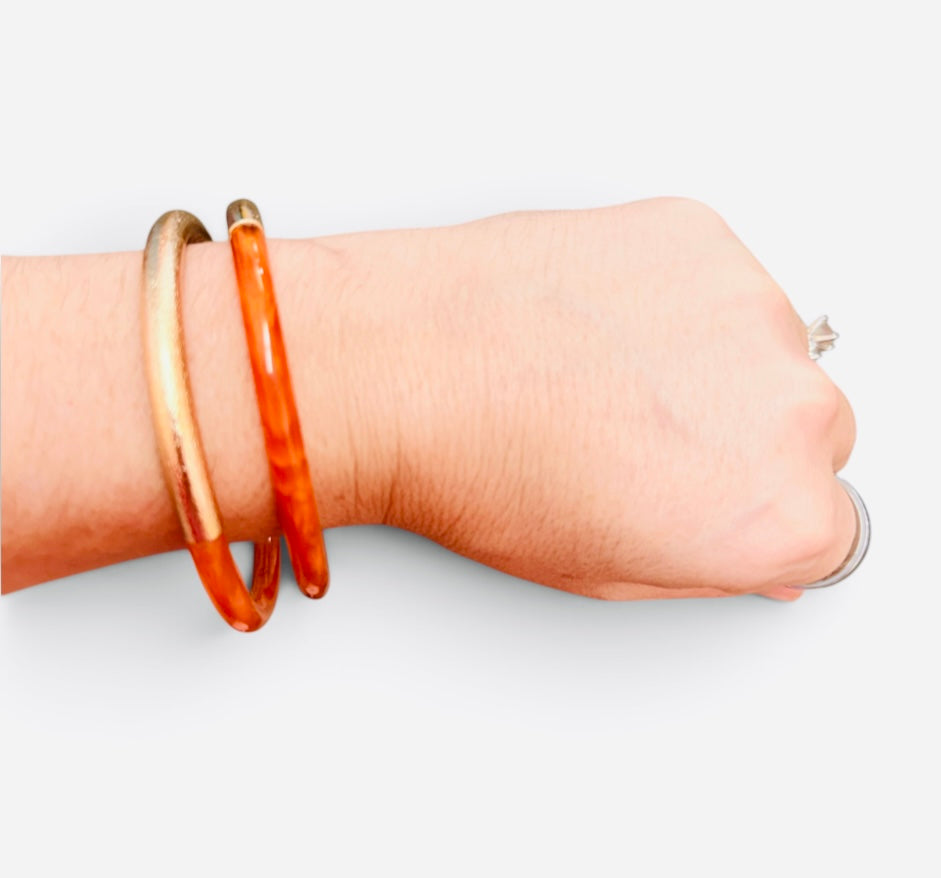 Orange enamel cuff bracelet with textured brushed gold-tone finish.
