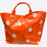 Orange polka dot tote bag with shiny finish and white dots.
