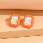 Oversized orange rhinestone stud earrings with bold sparkle.