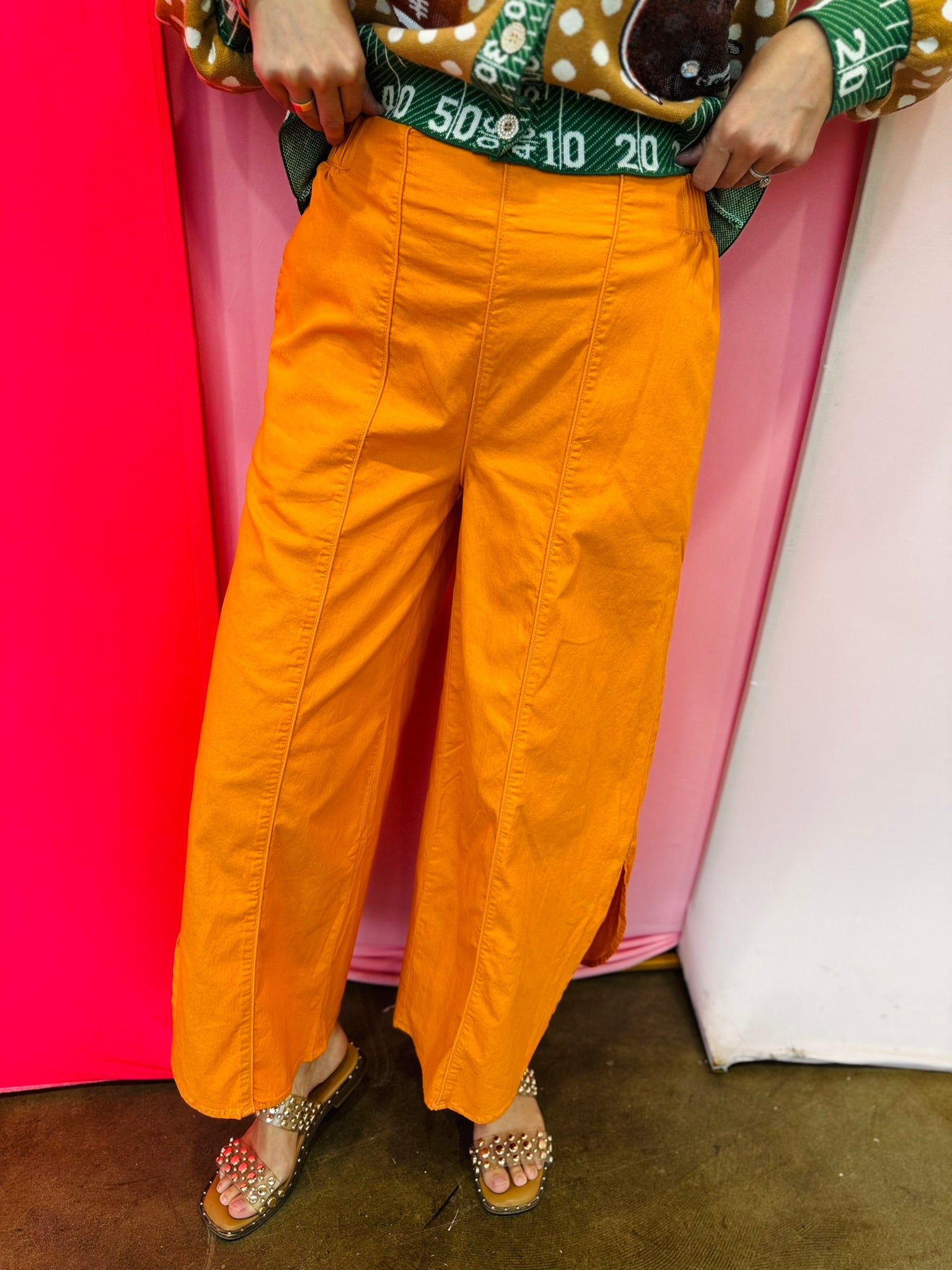 Orange wide leg washed denim pants with tulip hem and elastic waistband.