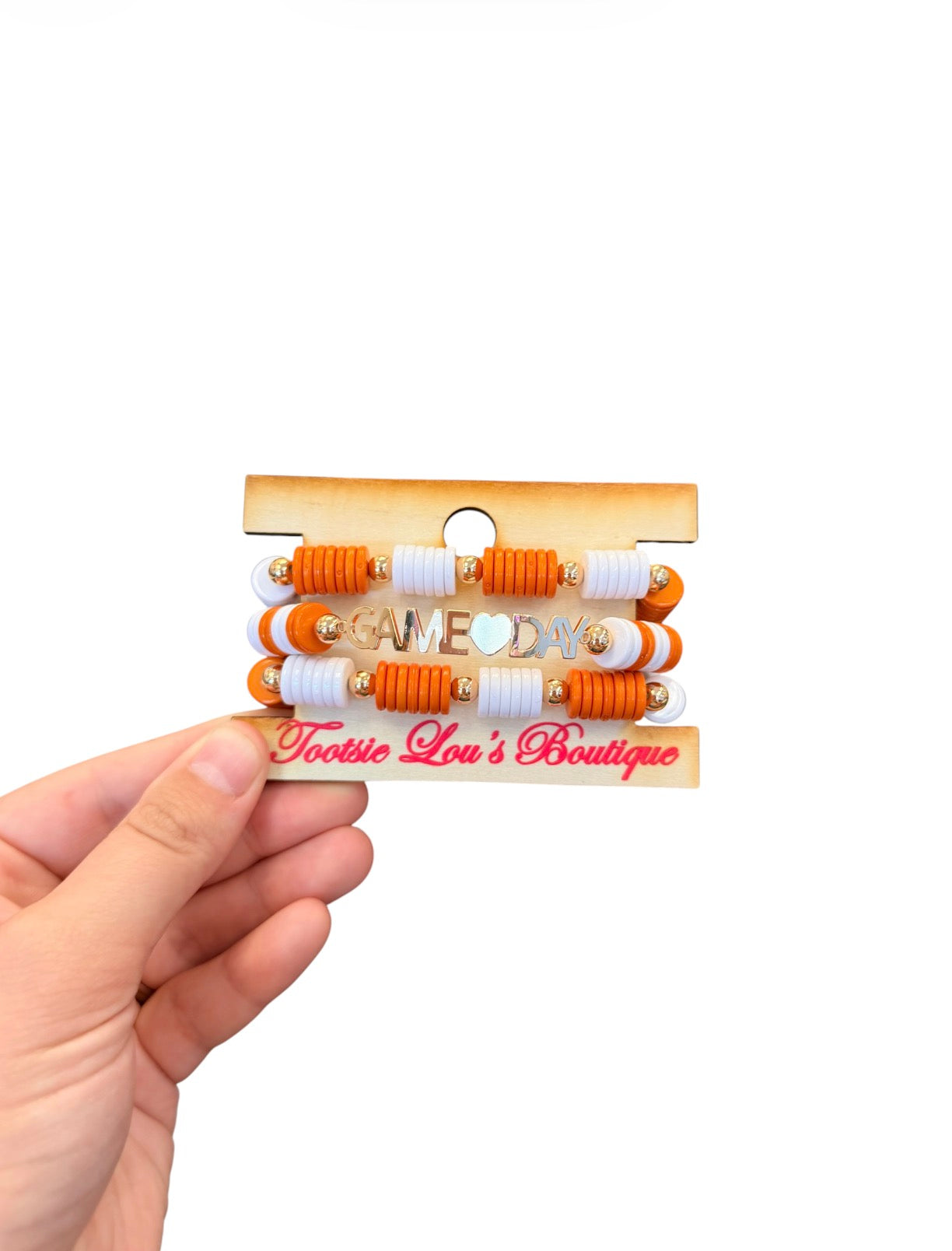 Orange and white Game Day bracelet stack with gold charm accents.