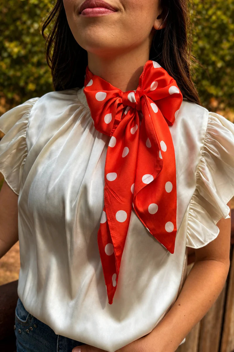 Orange and white silky polka dot scarf with versatile styling options.