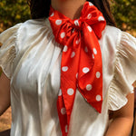 Orange and white silky polka dot scarf with versatile styling options.