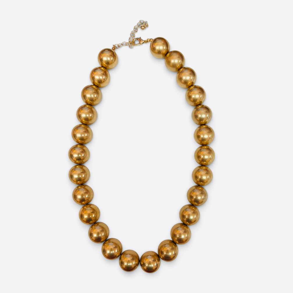 Oversized glossy gold-tone bubble bead necklace with adjustable chain.