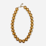 Oversized glossy gold-tone bubble bead necklace with adjustable chain.