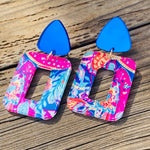 Cobalt stud earrings with pink-and-blue tropical geometric acrylic drops, lightweight and hypoallergenic.
