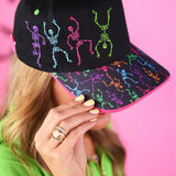 Black Halloween hat with colorful purple, pink, blue, green, and orange embroidered skeletons.