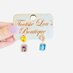 Pastel rhinestone dangle earrings with pink, yellow, and blue stones framed in gold trim.