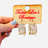 Clear acrylic hoop earrings with pearl bead accents and thin gold wire trim.