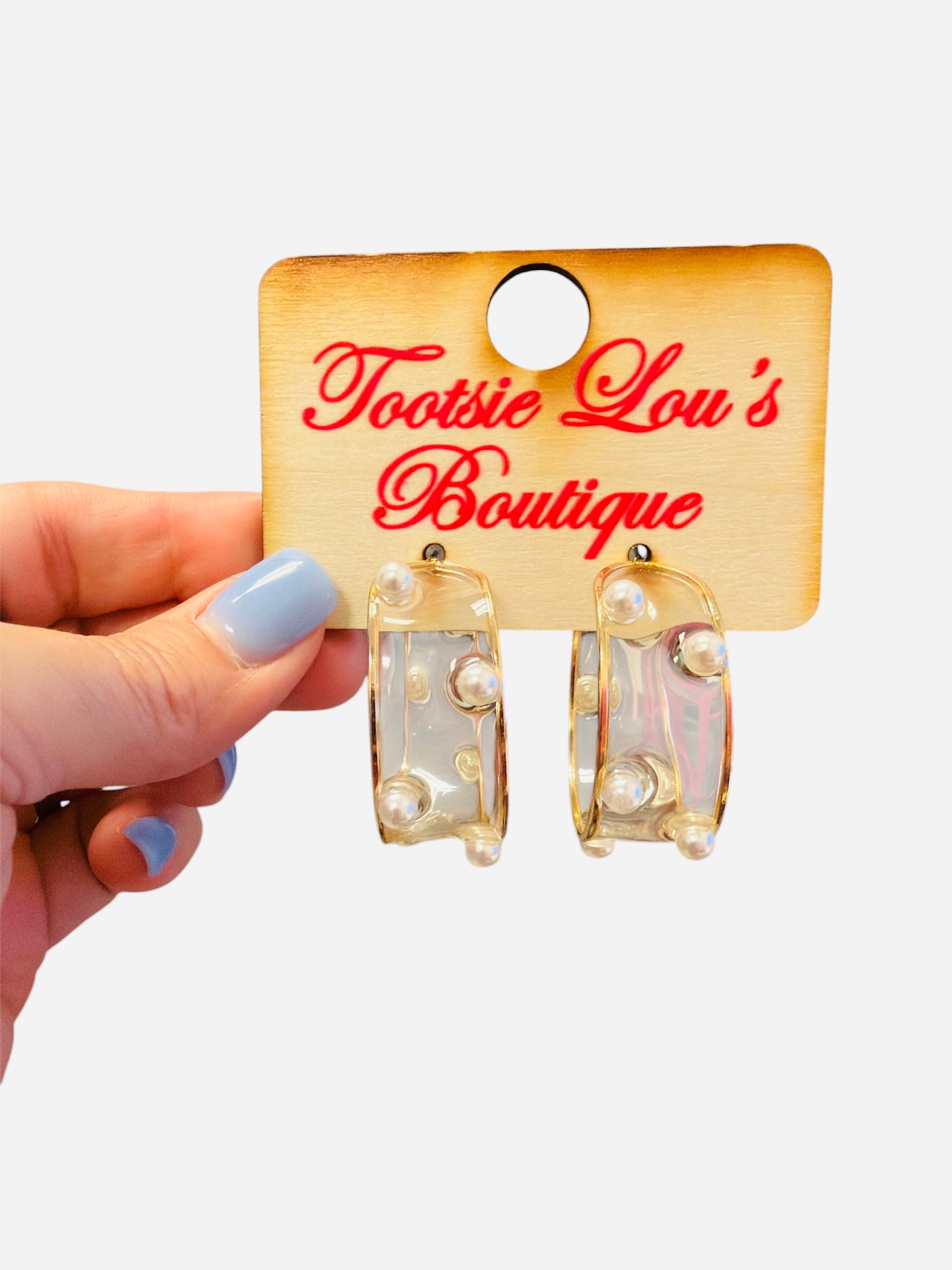 Clear acrylic hoop earrings with pearl bead accents and thin gold wire trim.