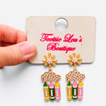 Pearl cloud earrings with dangling yellow, green, and pink pencils and floral studs.