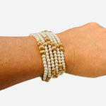 Set of five water-resistant pearl and gold beaded stretch bracelets with elegant textured shine.