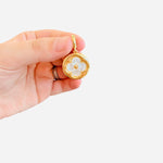 Gold mother-of-pearl floral charm with open circle frame, bead center, and lobster clasp for scarves.