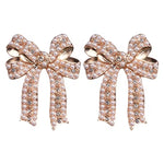 Gold bow stud earrings with rhinestones and centered faux pearl.