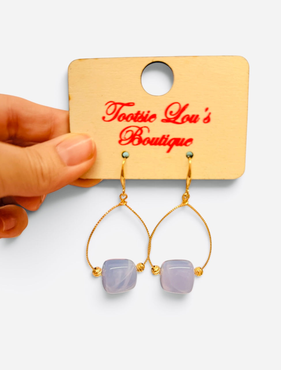 Periwinkle marbled bead earrings with gold-tone teardrop frames and gold accents.