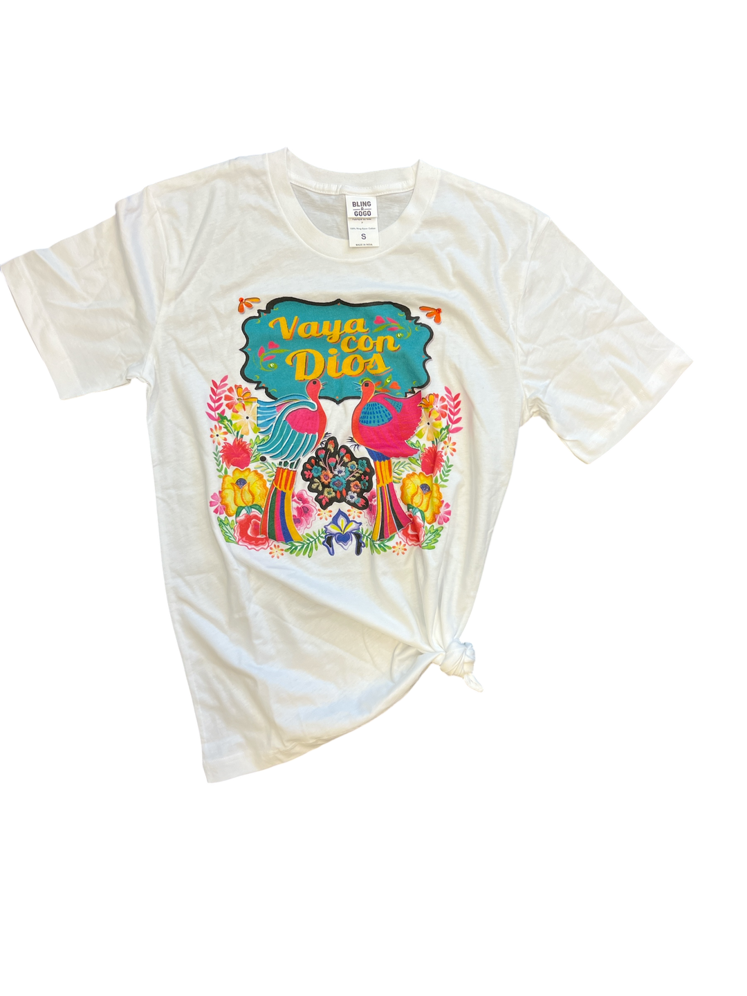 Flat lay of the Vaya Con Dios Tee on a plain surface, displaying the colorful floral print and rhinestone embellishments on the front.