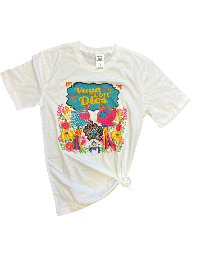 Flat lay of the Vaya Con Dios Tee on a plain surface, displaying the colorful floral print and rhinestone embellishments on the front.