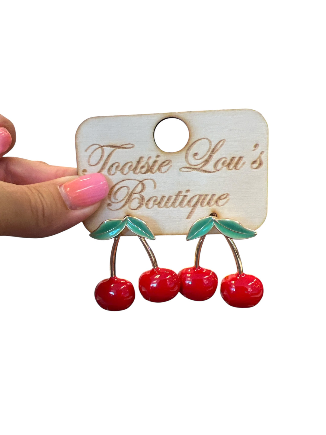 Enamel red cherry stud earrings that dangle with green leaves and gold stems.