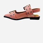 Pink pointed-toe flats with bold silver double buckle straps and a slingback backstrap, combining vibrant color with edgy charm.