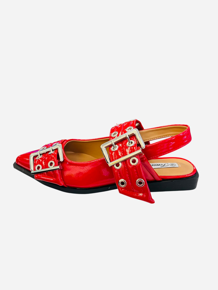 Red pointed-toe flats with bold silver double buckle straps and a slingback backstrap, combining vibrant color with edgy charm.