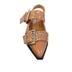 Tan pointed-toe flats with bold silver double buckle straps and a slingback backstrap, combining vibrant color with edgy charm.