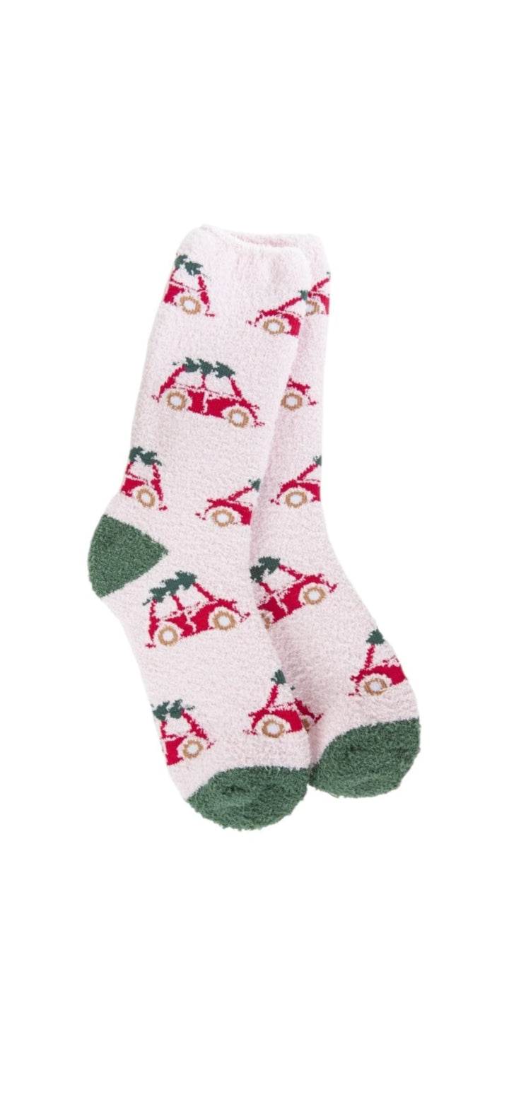A pair of plush, soft crew socks featuring a repeating pattern of a vintage red bug car with a Christmas tree on its roof. The socks have solid green heels and toes.
