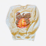 Cream sweatshirt with a fall pumpkin graphic and a leopard print bow.