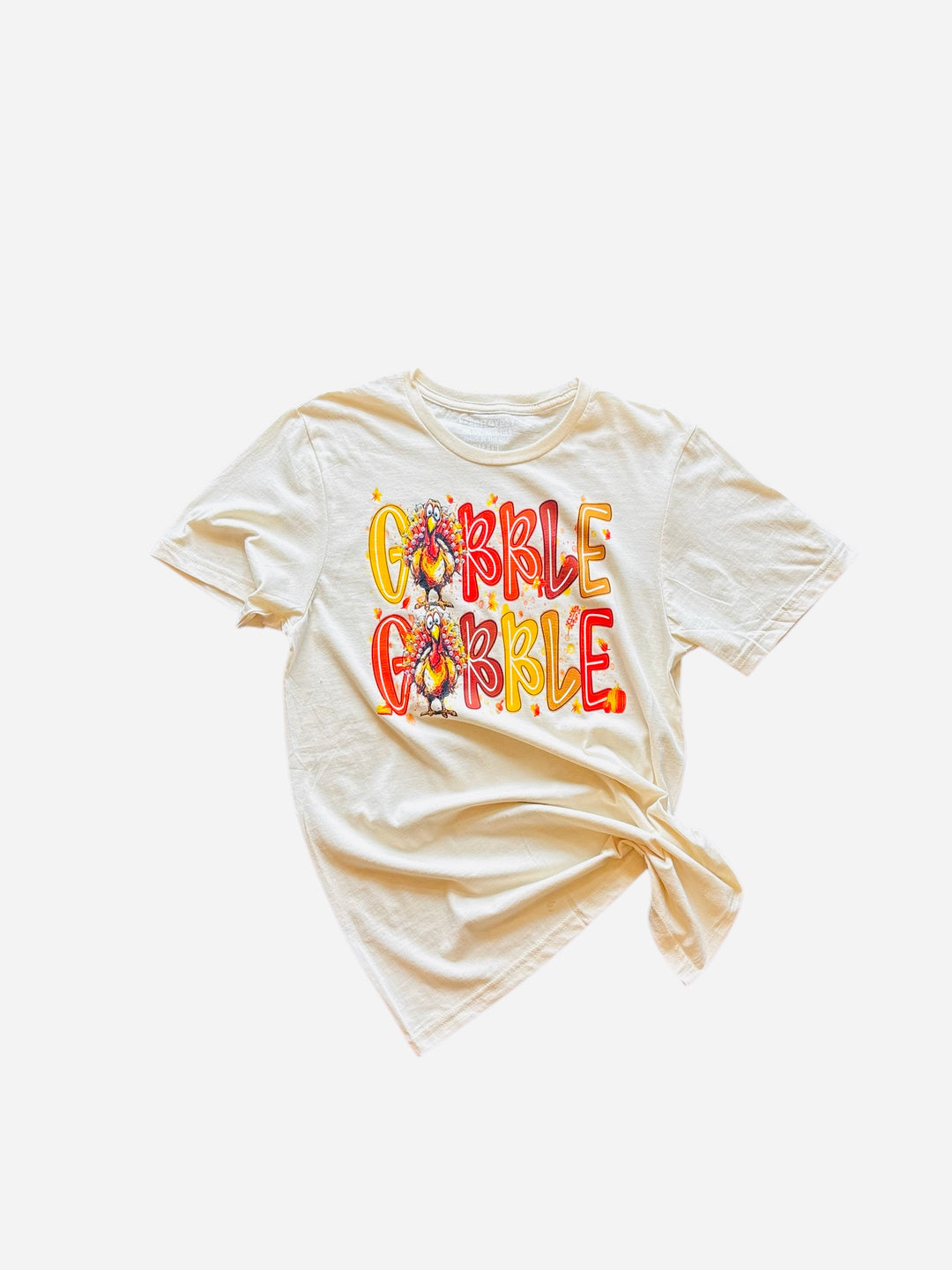 A cream-colored t-shirt with "Gobble Gobble" in fall colors and a rhinestone-adorned turkey design. 