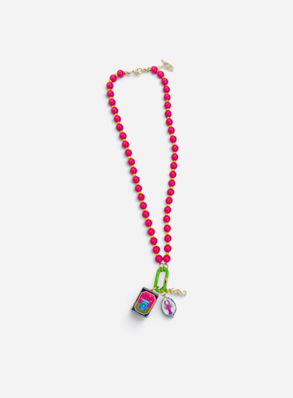 Hot pink beaded necklace with jasmine tea, lobster, and gold seahorse charms.