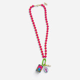 Hot pink beaded necklace with jasmine tea, lobster, and gold seahorse charms.