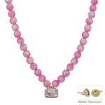 Pink beaded necklace with iridescent candy beads and rectangle crystal charm, magnetic clasp.