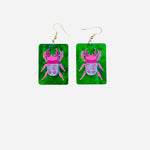 Lightweight rectangle earrings with pink beetle design on emerald green background.