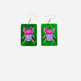 Lightweight rectangle earrings with pink beetle design on emerald green background.